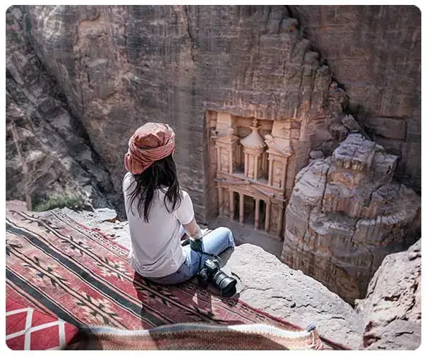 Travelers exploring the historic ancient city of Petra in Jordan under a clear blue sky. Travelers exploring the historic ancient city of Petra in Jordan under a clear blue sky.